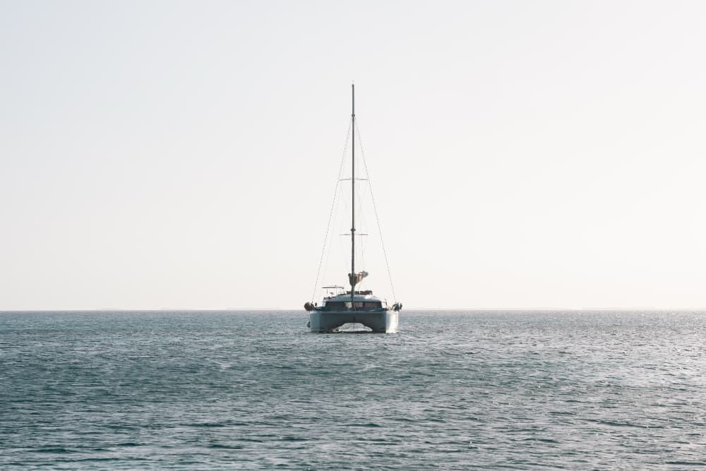 A sailboat is visible on calm water under a clear sky.