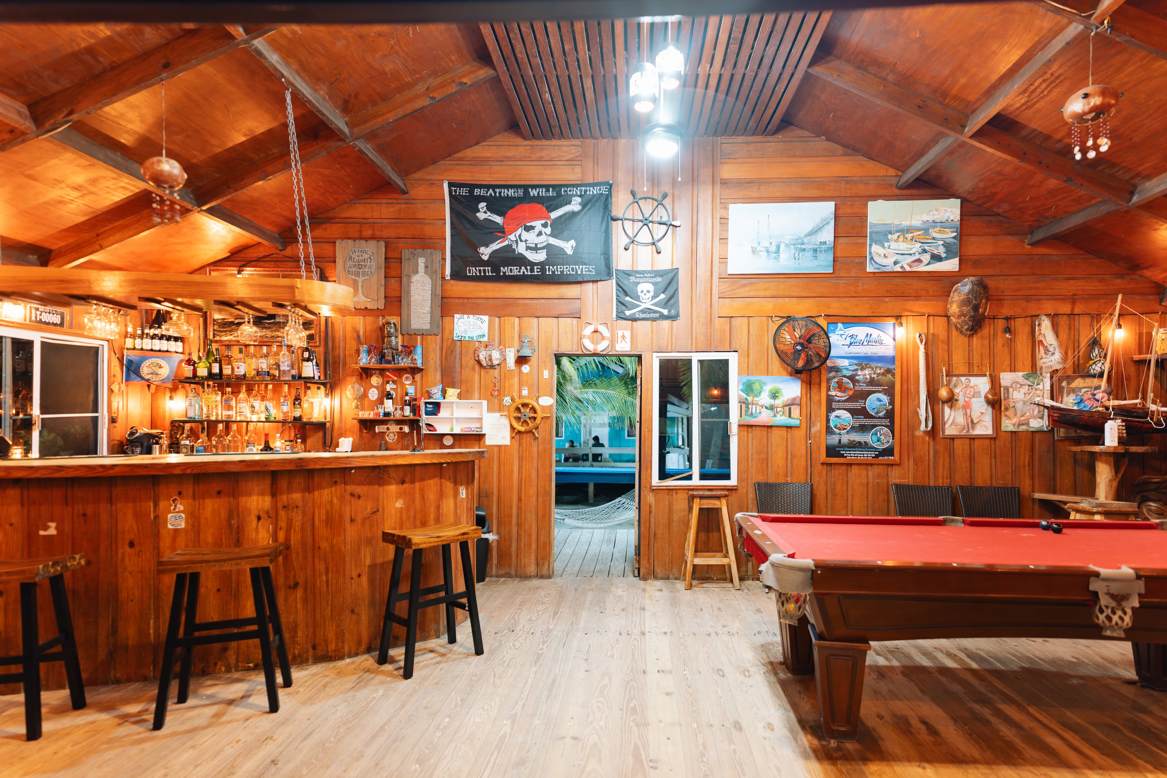 Cozy wooden interior of a bar featuring a pool table and nautical decor.