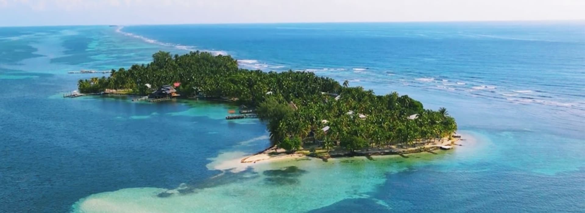 Aerial view of a tropical island surrounded by turquoise waters.