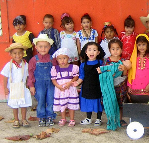 A group of Belizean children smiling and posing for a photo