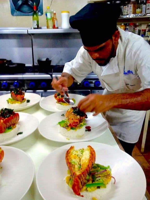 A chef plating elegant lobsters for dinner service.